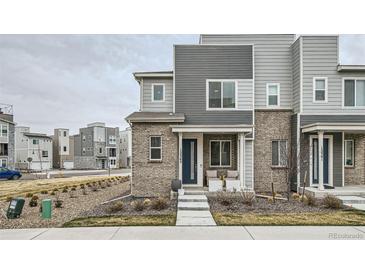 Modern townhome featuring mixed siding, stone accents, and a charming front porch offering stylish curb appeal at 12345 Festival Ln, Thornton, CO 80241