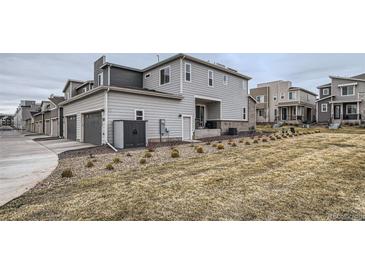 View of the home's rear facade with a two-car garage and low maintenance landscaping at 12345 Festival Ln, Thornton, CO 80241