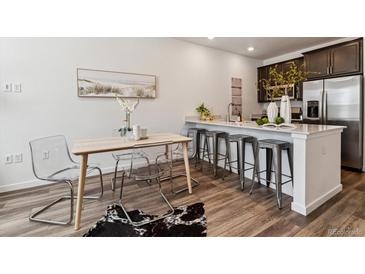 Stylish kitchen features a breakfast bar with seating and sleek, modern appliances at 2036 S Vance Way, Lakewood, CO 80227