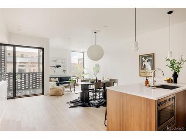 Bright living room featuring a modern design with hardwood floors and a large sliding glass door to the patio at 3233 Tejon St # 103, Denver, CO 80211