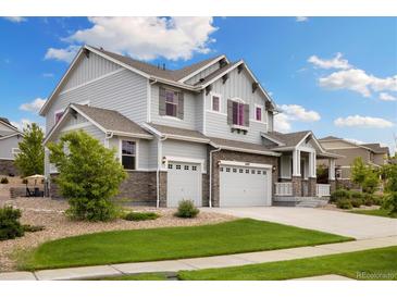 Beautiful two-story home with gray siding, stone accents, well-manicured lawn, and an attached two-car garage at 6692 S Robertsdale Way, Aurora, CO 80016