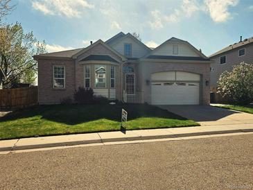 Charming single-story home with brick facade, attached garage, and manicured front lawn at 11144 Navajo St, Northglenn, CO 80234