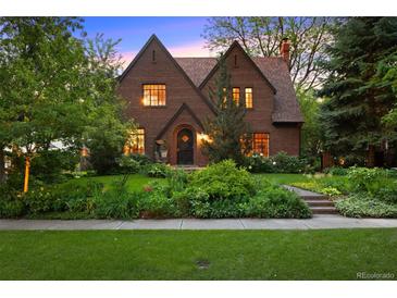 Charming brick two-story home with lush landscaping and mature trees providing curb appeal at 1960 Hudson St, Denver, CO 80220