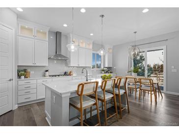 An open kitchen features quartz countertops, stainless steel appliances, and a breakfast bar with seating at 20272 Terrace View Dr, Parker, CO 80134