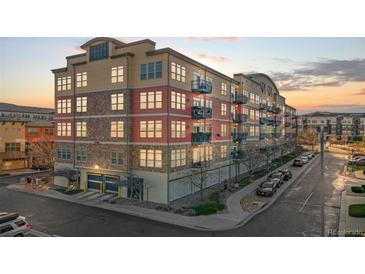 Multi-story condo building featuring stone and siding exterior, with garage and balcony views at 13456 Via Varra # 428, Broomfield, CO 80020