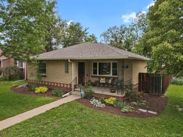 Charming brick home featuring a cozy front porch and a well-maintained, landscaped yard at 1600 Olive St, Denver, CO 80220