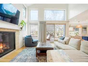Cozy living room with fireplace, plush seating, and natural light from large windows and sliding glass doors at 469 Tripp Dr, Golden, CO 80401