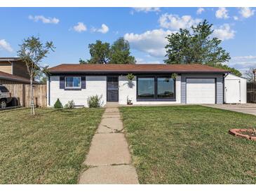 Charming single-story home featuring a well-manicured lawn, front porch and attached garage at 8641 Lowell Blvd, Westminster, CO 80031