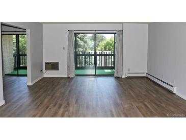 Bright living room featuring wood-look floors and sliding glass doors to a balcony at 14152 E Linvale Pl # 311, Aurora, CO 80014