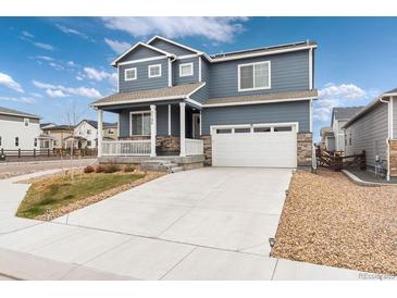 Charming two-story home featuring a covered porch, attached two car garage and mature landscaping at 2186 Prairie Smoke Dr, Monument, CO 80132