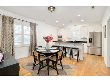 Bright kitchen and dining area with stainless steel appliances and hardwood floors at 150 S Harrison St # 106, Denver, CO 80209