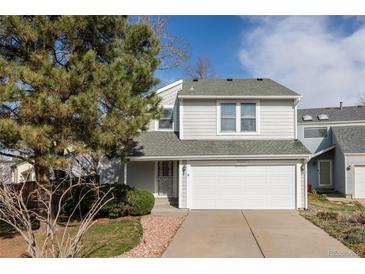 Charming two-story home featuring a well-maintained lawn, mature trees and a two car garage at 7883 S Windermere Cir, Littleton, CO 80120