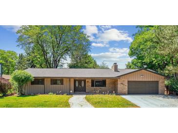 Charming ranch-style home with stone accents, manicured lawn, mature trees, and inviting walkway at 6330 E Vassar Ave, Denver, CO 80222