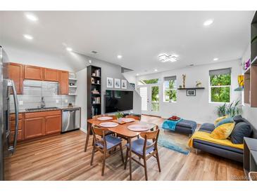 Bright living room featuring an open floor plan, modern furnishings, and beautiful hardwood flooring at 1106 Oak Cir, Lakewood, CO 80215