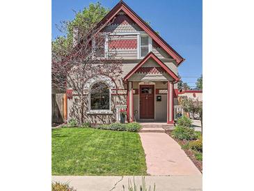 Charming two-story home featuring a well-manicured lawn, mature trees, and a welcoming red-trimmed entrance at 3047 Osceola St, Denver, CO 80212