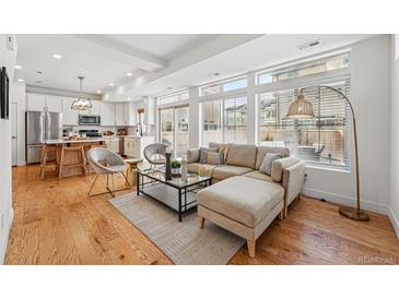 Bright open-concept living area with hardwood floors and lots of natural light at 10123 Zeno St, Commerce City, CO 80022