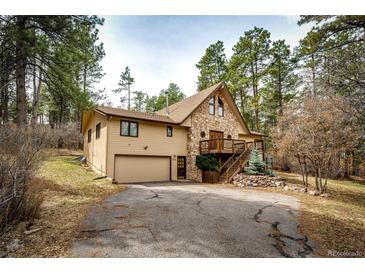 Charming home with stone accents, wood siding, attached garage, and a welcoming driveway at 530 Windmill Rd, Castle Rock, CO 80108