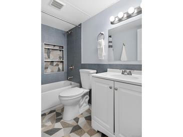 Stylish bathroom featuring a shower with gray tiles, unique mosaic shelving, and a white vanity at 2281 Vaughn # 104A, Aurora, CO 80014
