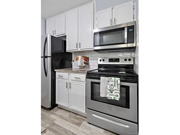 Efficient kitchen with stainless steel appliances, granite countertops, and subway tile backsplash at 2281 Vaughn # 104A, Aurora, CO 80014