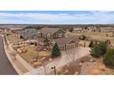 Beautiful two-story home with a three car garage, landscaped yard and basketball court on a manicured lot at 7635 Weaver Cir, Castle Rock, CO 80104