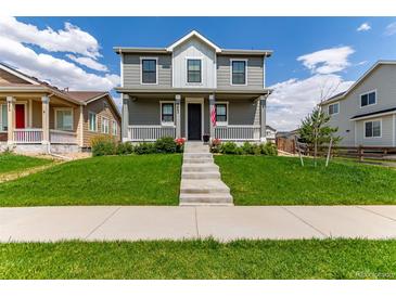 Charming two-story home with a well-manicured lawn and inviting front porch at 9862 Reunion Pkwy, Commerce City, CO 80022