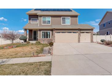 Charming two-story home with a well-maintained lawn, mature landscaping, and a three car attached garage at 4971 Ceylon Way, Denver, CO 80249