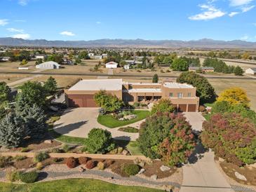 Stunning aerial view of an estate home with circular driveway and impeccable landscaping at 4719 Beverly Ln, Erie, CO 80516