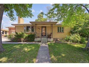 Charming brick home featuring a covered porch and well-maintained front yard at 6050 Marshall Ct, Arvada, CO 80003
