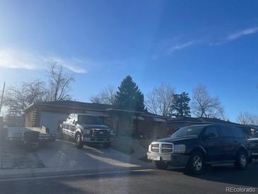Single story home featuring an attached garage and front yard at 2285 S Newton St, Denver, CO 80219
