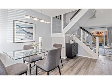 Elegant dining room with a glass table, modern lighting, and stylish decor and stairway at 3423 Madison Ave # X133, Boulder, CO 80303