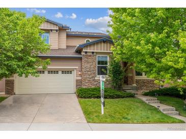 Charming two-story home with stone accents, a well-manicured lawn, and mature trees. A two car garage adds convenience at 2601 Pemberly Ave, Highlands Ranch, CO 80126