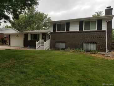 Brick ranch house with attached garage, front yard, and white railing at 1533 S Jamaica St, Aurora, CO 80012