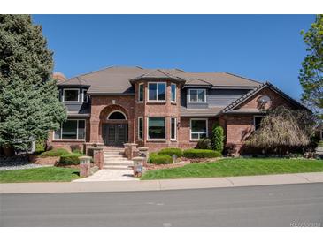 Stately brick home featuring a tile roof, manicured landscaping, and a welcoming entrance at 1193 Phipps Ct, Highlands Ranch, CO 80126