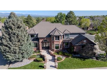 Beautiful two-story home showcasing a manicured lawn, stone pathway, and mature trees at 1193 Phipps Ct, Highlands Ranch, CO 80126