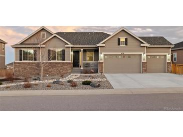 Charming exterior of this two-story home featuring a three car garage and beautifully landscaped front yard at 6728 Mentha Dr, Castle Rock, CO 80108