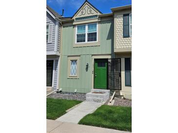 Charming two-story townhouse with a green exterior, landscaped front yard, and inviting entrance at 1641 S Idalia Cir # F, Aurora, CO 80017