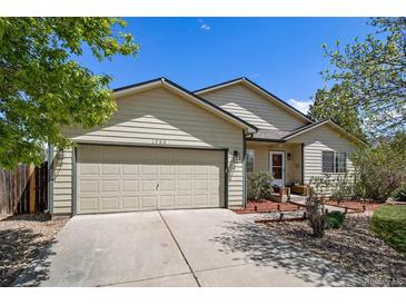 Charming one-story home with neutral siding, lush landscaping, and a two-car garage at 1933 Chestnut St, Fort Lupton, CO 80621