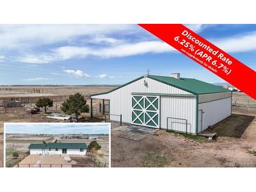 Spacious barn with white exterior, green roof, and large doors, offering versatile space at 32350 E 137Th Way, Brighton, CO 80603
