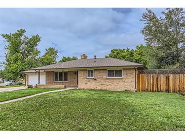 Charming brick home with a well-maintained lawn and mature trees at 7995 Robin Ln, Denver, CO 80221