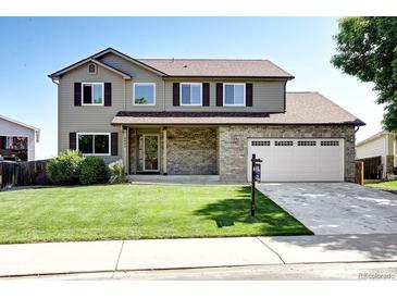 Charming two-story home featuring a well-maintained lawn, brick accents, and a two-car garage at 4863 Quail Ct, Frederick, CO 80504