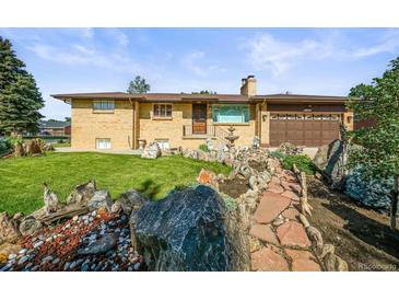 Charming brick ranch-style home with a well-manicured front yard and mature landscaping at 5703 Field St, Arvada, CO 80002
