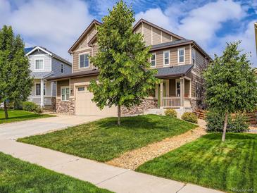 Charming two-story home featuring a well-manicured lawn, stone accents, and an inviting front porch at 30 Sun Up Ct, Erie, CO 80516