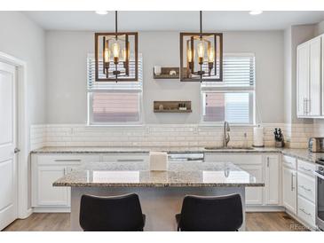Bright kitchen featuring granite countertops and modern light fixtures over the island at 4260 E Warren Ave # 5, Denver, CO 80222