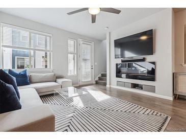 Stylish living room with a large TV, modern furniture, and a sliding door to the outside at 4260 E Warren Ave # 5, Denver, CO 80222