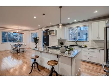 Modern kitchen with white cabinets, granite island, and stainless steel appliances at 291 S Franklin St, Denver, CO 80209