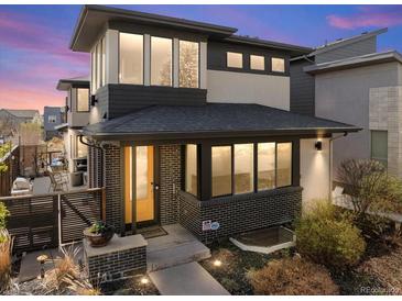 Charming two-story home featuring a modern design, brick accents, and a welcoming yellow front door at 1730 W 67Th Ave, Denver, CO 80221
