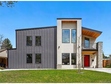 Striking two-story modern home featuring metal and stucco finishes, a balcony, and a bright red front door at 1220 S Elm St, Denver, CO 80246