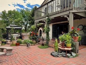 Large brick patio with gazebo, grill, & lush landscaping at 4696 S Yates St, Denver, CO 80236