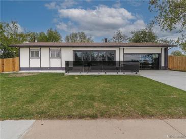 Charming single-story home featuring a well-manicured lawn and modern design elements at 6735 W 2Nd Ave, Lakewood, CO 80226