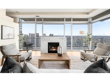 Bright living room featuring a marble fireplace and floor-to-ceiling windows with city views at 2001 Lincoln St # 3121, Denver, CO 80202